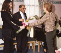 Sabina Gatrad presenting  Mrs Gatrad with flowers on behalf of the Manor Hospital at the OBE celebration. 